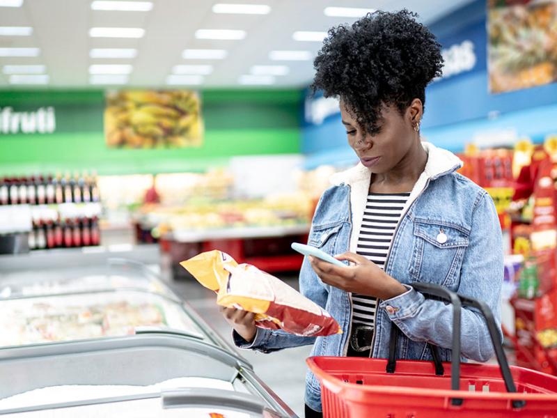 woman scanning a barcode at grocery store with her phone