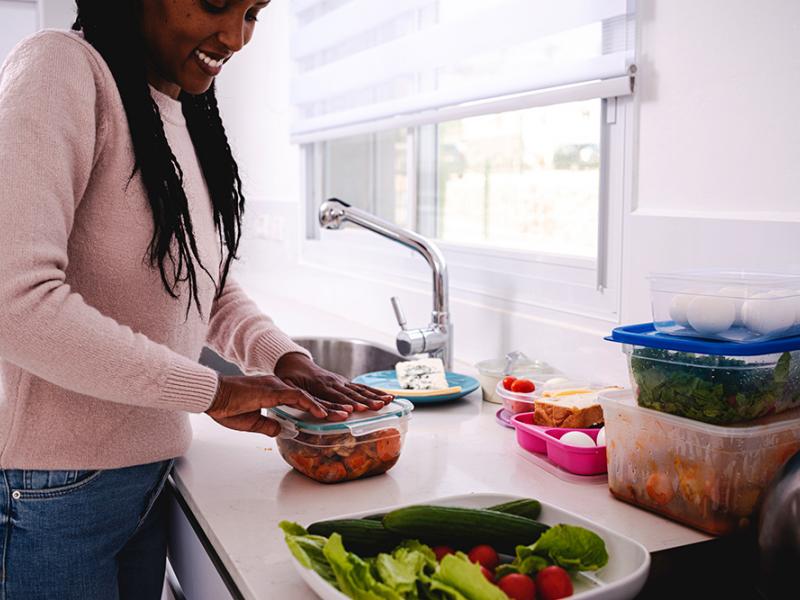 Woman putting leftovers in storage container