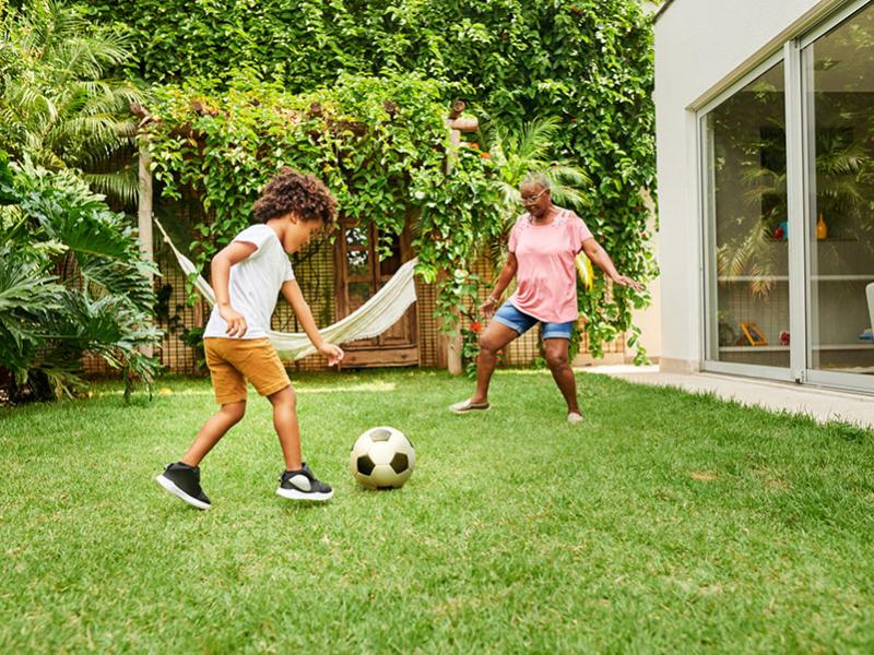 boy and grandma kicking soccer ball