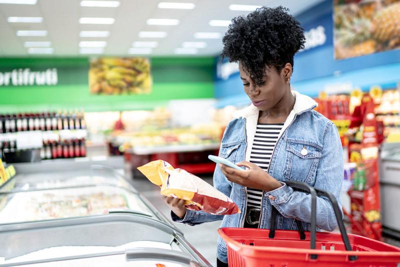 woman scanning a barcode at grocery store with her phone