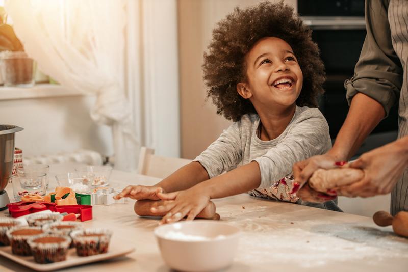 child rolling out dough