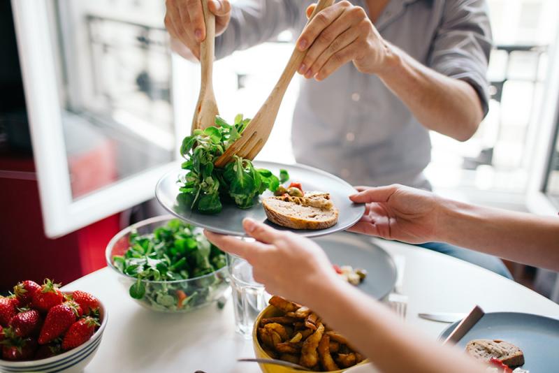 hands serving salad